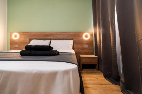 a bed with two black pillows on top of it at Elysium Self Check-In Rooms in Trezzo sullʼAdda