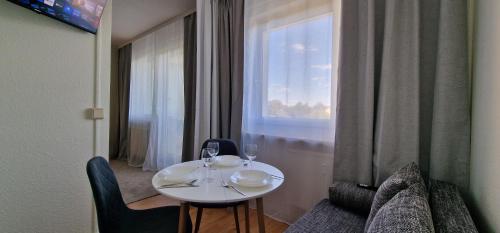 a white table with two wine glasses and a window at StadtZentrum Apartment mit Parkplatz in Chemnitz