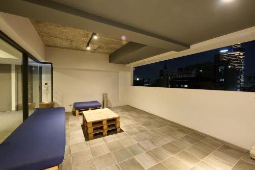 a room with a table and a bench and a window at Doudian DDiNN Hotel in Taichung