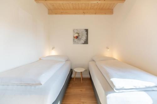 two beds in a room with a table at Huus Mullewap in Kating