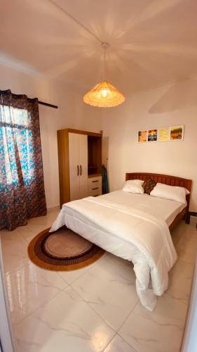 a bedroom with a large bed and a chandelier at Cozy Corner 1 in Flic-en-Flac