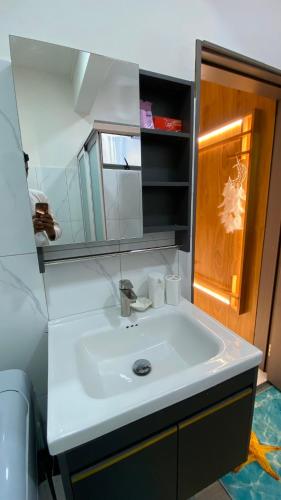 a bathroom with a white sink and a mirror at Cozy Corner 1 in Flic-en-Flac