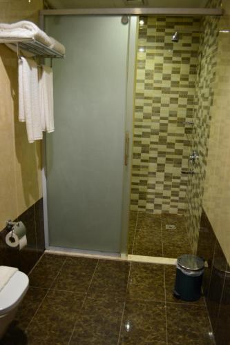a shower with a glass door in a bathroom at فندق الشهباء الفيحاء Hotel Al Shahba Al Faiha Jeddah in Jeddah