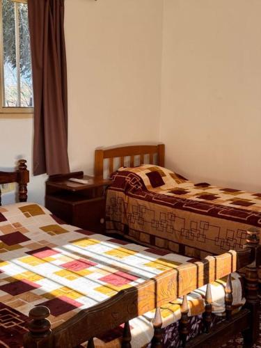 a bedroom with two beds and a table and a window at Don Luis Alberto in El Puesto