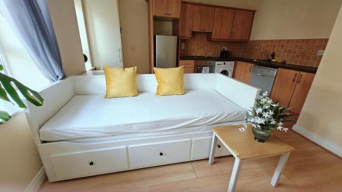 a white couch in a kitchen with a table at Donabate Entire Apt- 10min Airport in Donabate