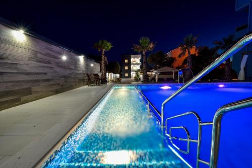 a swimming pool at night with blue lighting at Boutique Apartments Ad Astra in Bibinje