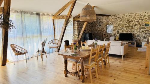 a dining room and living room with a table and chairs at Le Refuge du Cagire in Aspet