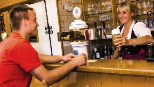 a man and a woman standing at a bar at Landhotel Röfleuten in Pfronten