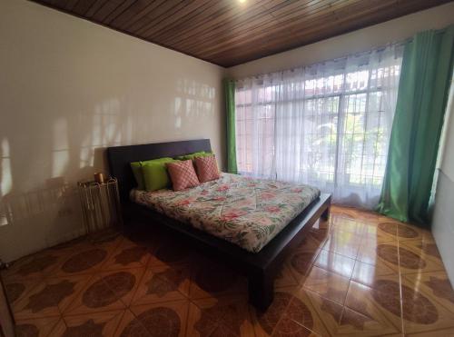 a bed in a room with a window and a bed with pillows at Casa Victoria in San José