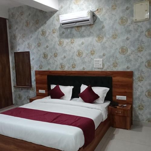 a bedroom with a large bed with red pillows at Hotel HAV Jaipur in Jaipur