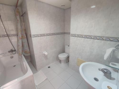 a white bathroom with a sink and a toilet at Perla Hôtel in Fès