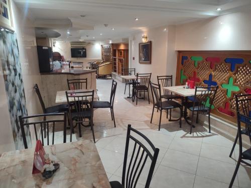 a restaurant with tables and chairs in a room at Perla Hôtel in Fès