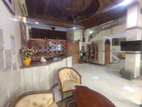 a living room with two chairs and a bar at Perla Hôtel in Fès