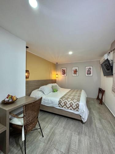 a bedroom with a bed and a table and a desk at Hotel Buena Vista in Bucaramanga