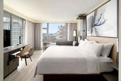 a hotel room with a large bed and a desk at Victoria Marriott Inner Harbour in Victoria