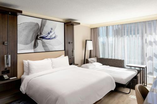 a hotel room with a large white bed and a window at Victoria Marriott Inner Harbour in Victoria
