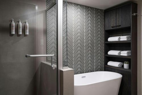 a bathroom with a shower and a white tub at Victoria Marriott Inner Harbour in Victoria