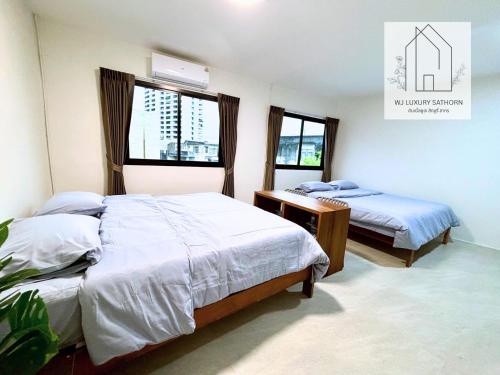 une chambre avec deux lits et deux fenêtres dans l'établissement WJ Luxury Sathorn, à Bangkok