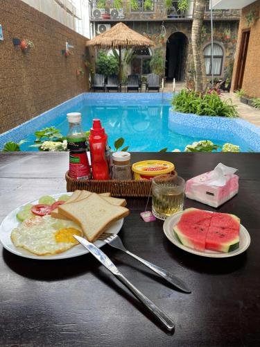 een tafel met borden eten op een tafel bij een zwembad bij Serena Tam Coc Hotel & Villa in Ninh Binh