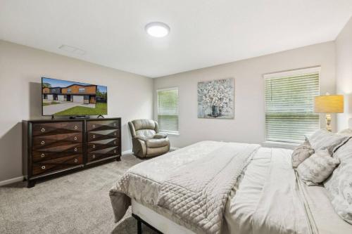 a bedroom with a bed and a chair and a dresser at Isabella Ct Townhome in Orange Park