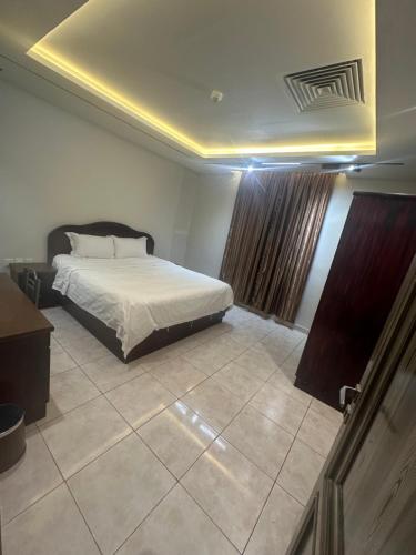 a bedroom with a bed and a tv in it at الأوائل الذهبية للشقق المخدومة فئة اقتصادي in Taif