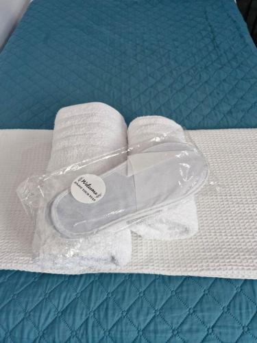 un contenitore di plastica su un letto con asciugamani di Georgias house 7 min from Athens airport a Artemida