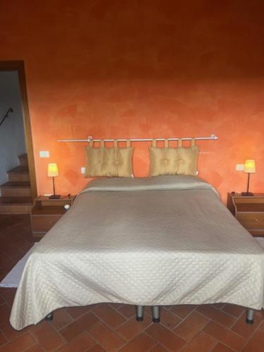 a bed in a room with two nightstands and two lamps at Agriturismo I Poggi in Impruneta
