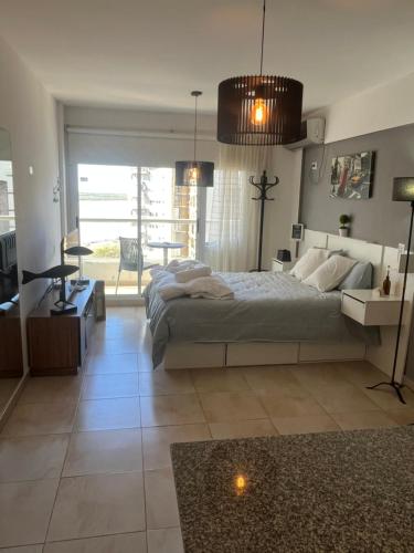 Un dormitorio con una cama grande y una mesa. en Rosario frente al Rio, en Rosario