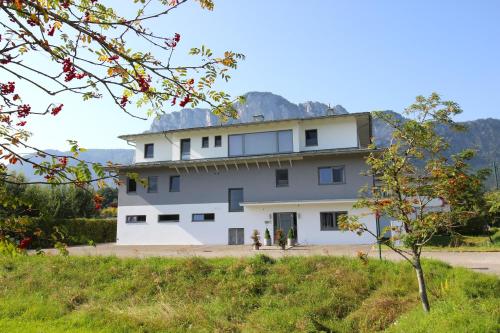 a large white building with a mountain in the background at Lorenzhaus Exclusive Residence in Sankt Lorenz