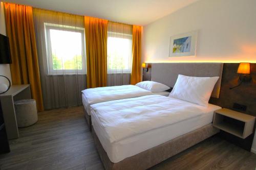 a hotel room with two beds and two windows at Lorenzhaus Exclusive Residence in Sankt Lorenz