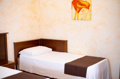 a bedroom with a bed and a painting on the wall at Bed & Breakfast Giardini Di Marzo in Lecce