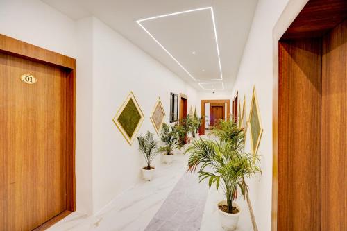 a corridor with potted plants in a hallway at Hotel O Luxury Inn in Prayagraj