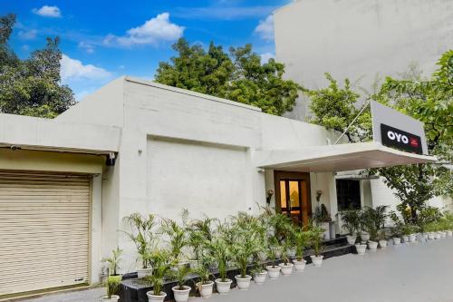 a white building with plants in front of it at Hotel O Luxury Inn in Prayagraj