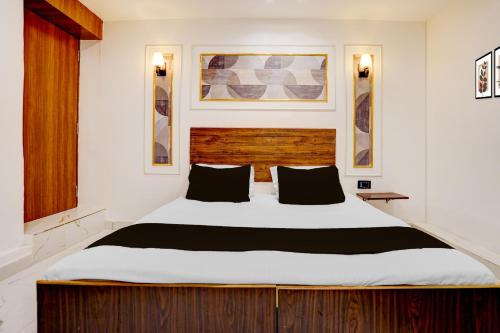 a bedroom with a large white bed with black pillows at Hotel O Luxury Inn in Prayagraj