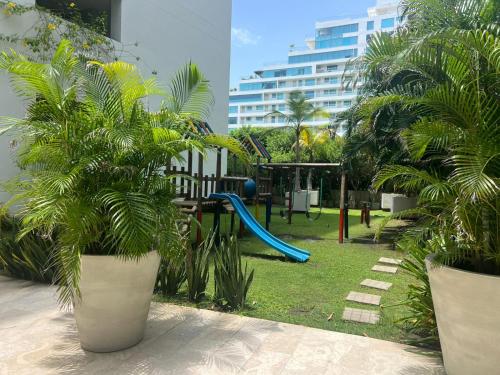 a playground with a blue slide and palm trees at Morros Vitri directo al Mar in Cartagena de Indias