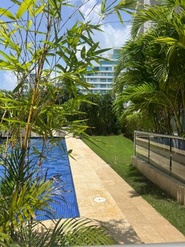a blue pool in a park with trees and a building at Morros Vitri directo al Mar in Cartagena de Indias