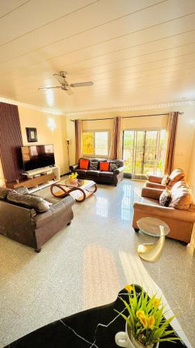 a large living room with several couches and tables at Spacious, modern Yaoundé villa in Yaoundé