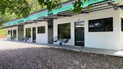 a white building with two chairs in front of it at Villas Anna Bertha 2 noches minimo in San Isidro