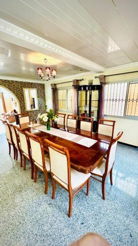 a dining room with a large wooden table and chairs at Spacious, modern Yaoundé villa in Yaoundé