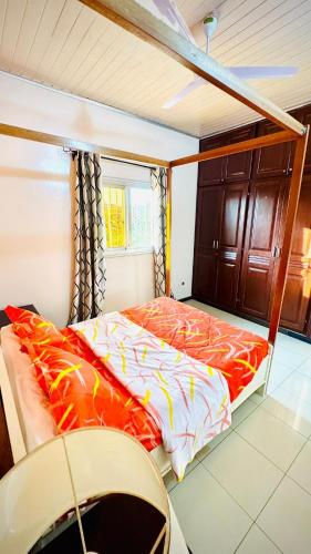 a bedroom with a bed with orange and white sheets at Spacious, modern Yaoundé villa in Yaoundé
