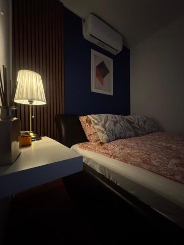a bedroom with a bed and a table with a lamp at Apartman Alchemist I in Bosanska Dubica