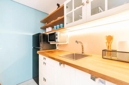 a kitchen with white cabinets and a wooden counter top at A casa dos Parladoiros in Mos
