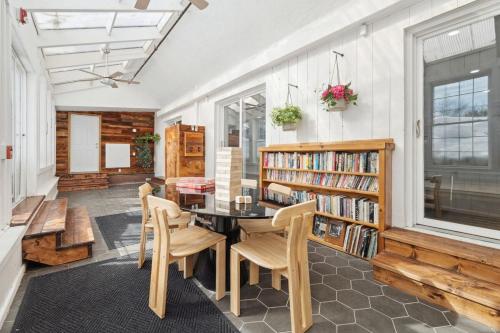 a room with a table and chairs and a book shelf at The birch House Heated Pool, Sauna, Hot Tub & More in Dover
