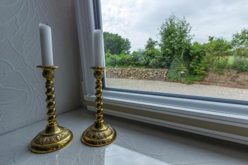 two candles sitting on a window sill in front of a window at Naturperlen in Rødekro