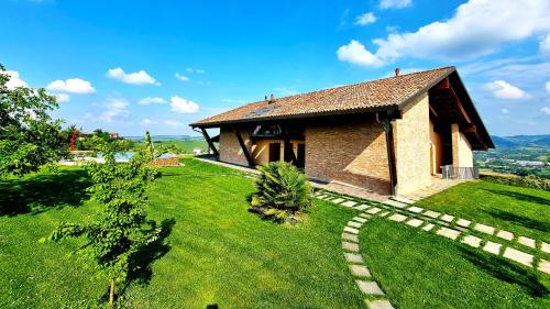 a small house on top of a grassy hill at Ca 'nsel Bric in Canelli