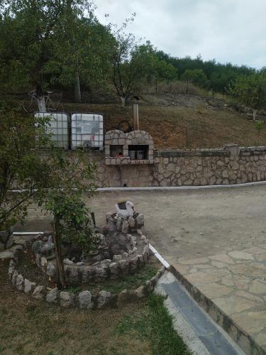 a stone wall next to a road with a building at Stefke in Lučani