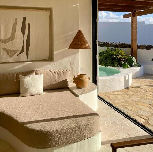 a bedroom with a couch and a view of the ocean at Canaryislandshost l Risco Suite Lanzarote in Famara