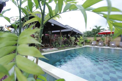 a swimming pool in front of a villa at Villa D'Uma in Ubud