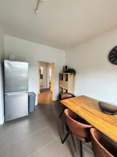 a kitchen with a wooden table and a refrigerator at 6P Zentrale Suite mit Balkon & Parkplatz in Witten