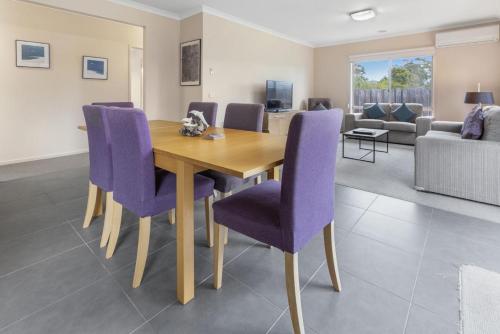 a dining room with a wooden table and purple chairs at Toonalook Retreat in Paynesville